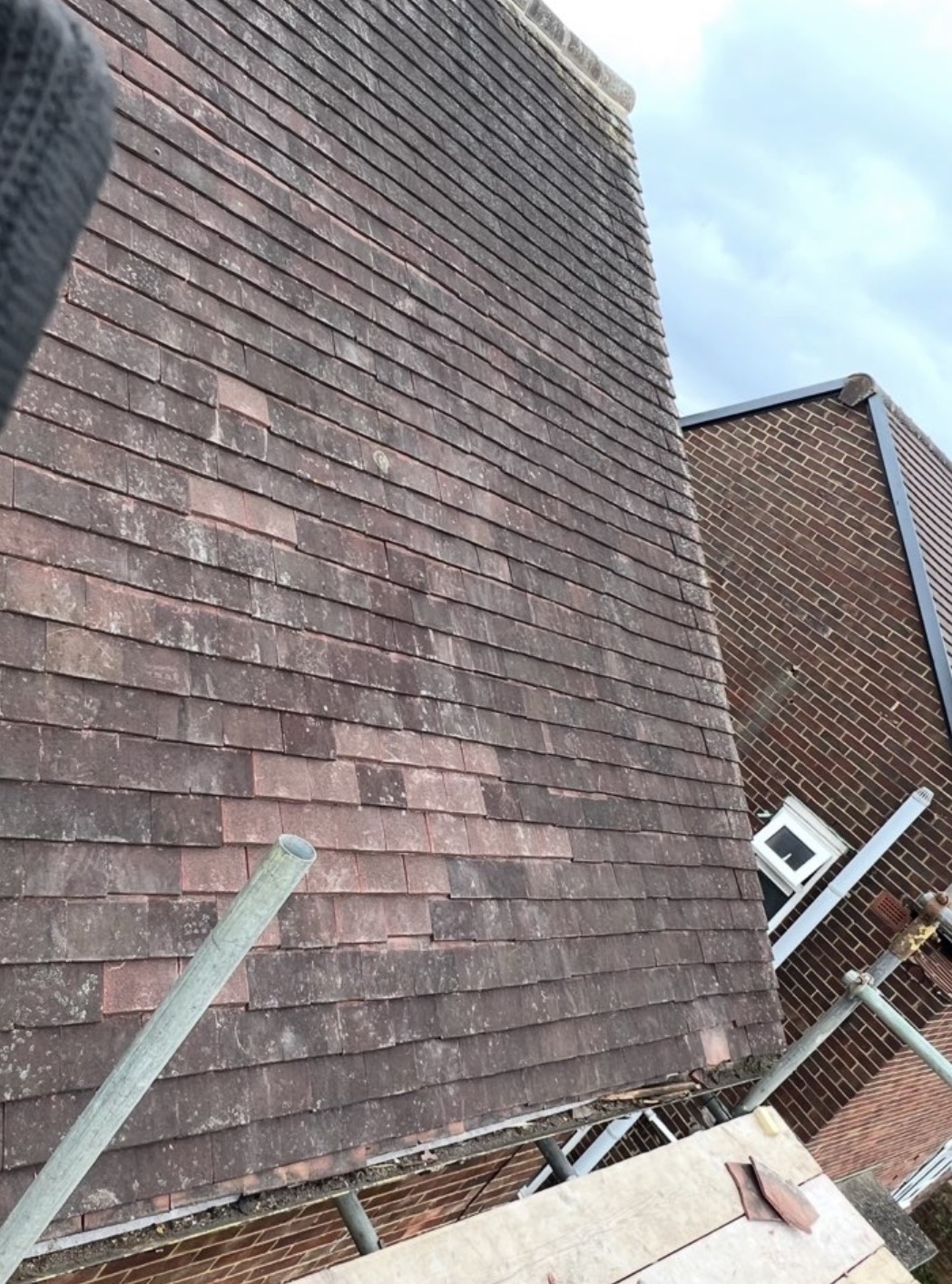 Repaired plain clay tile roof slope with replaced tiles